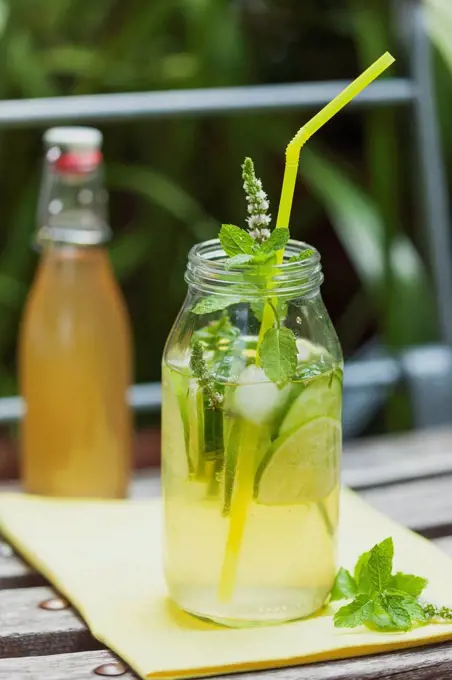 Glass of ice-cooled homemade cucumber lime lemonade with mint leaves