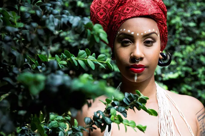 Portrait of young woman with piercings wearing traditional Brazilian headgear