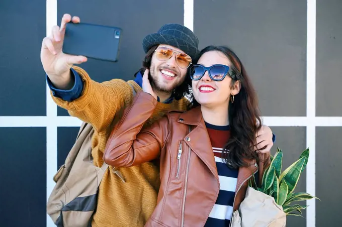 Happy young couple taking selfie with smartphone