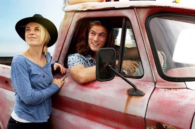 Smiling young couple with an old pick up