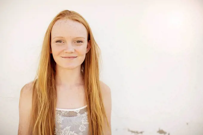 Portrait of smiling girl with long red hair