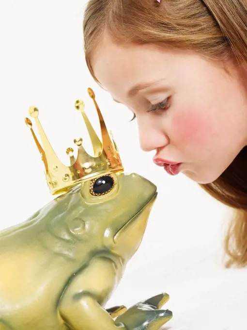 Portrait of little girl kissing frog king