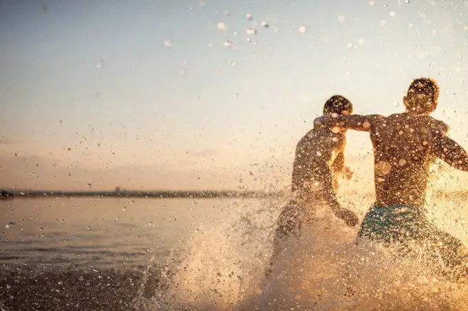 Two friends running in water