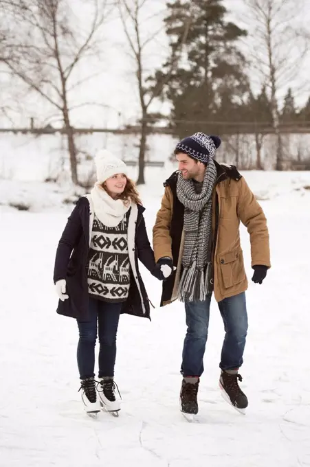 Young couple ice skating in nature