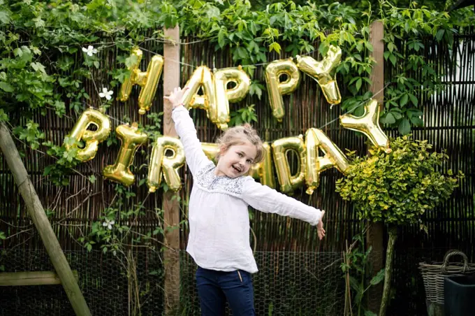 Portrait of girl in the garden with decoration for Birthday Party in the background