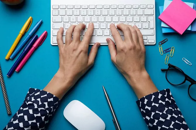 Top view of woman using computer keyboard on desk