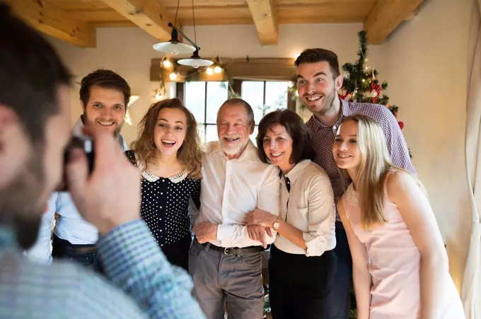 Family posing for a photo at Christmas tree