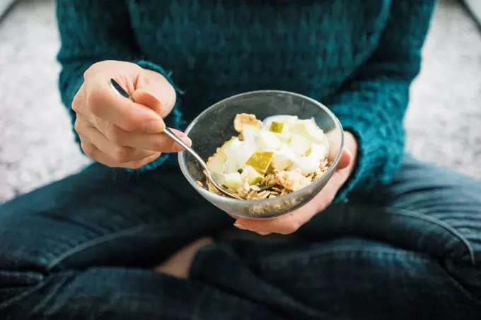 Close-up of woman eating fruit muesli