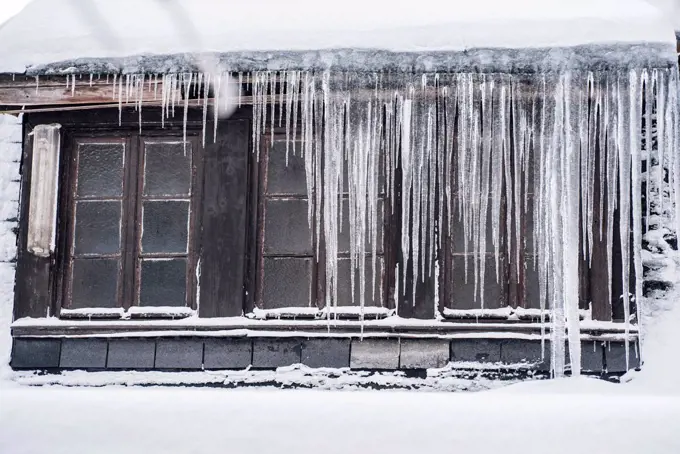 Icicles hanging down from a roof top in winter