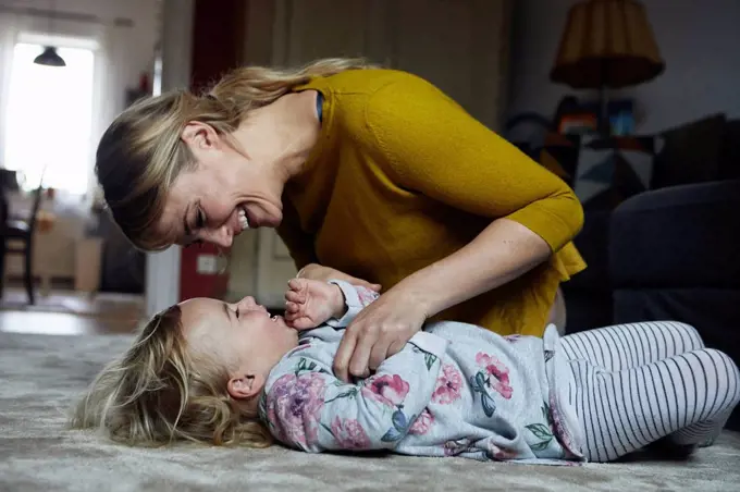 Mother and little daughter having fun together at home