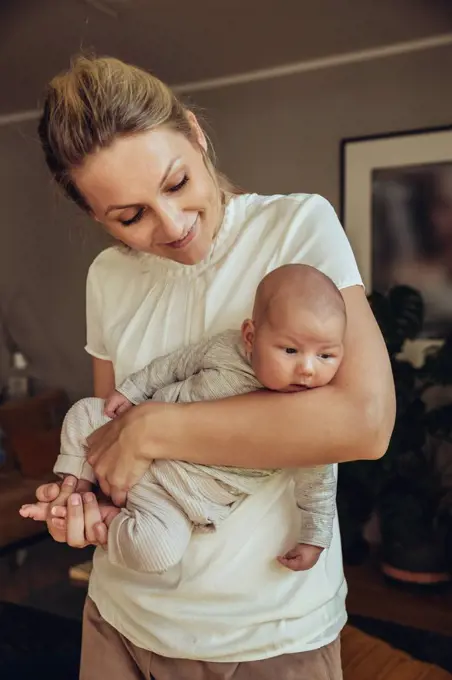 Newborn baby being held in motherƒ.s arms