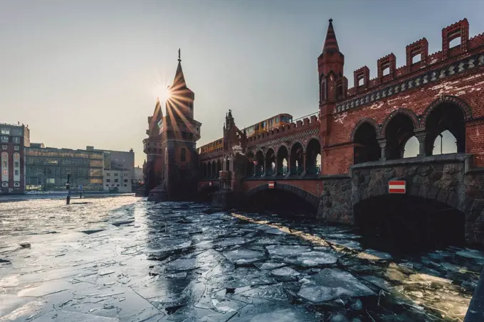 Germany, Berlin, view to Oberbaum Bridge with driving underground train in winter