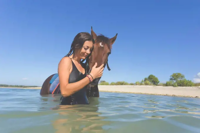 Indonesia, Bali, Woman with horse in the water