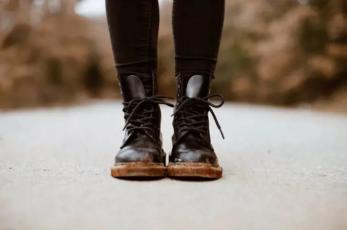 Woman wearing black boots, partial view