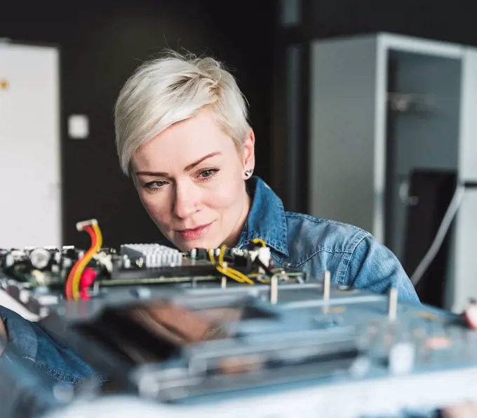 Woman examining computer equipment