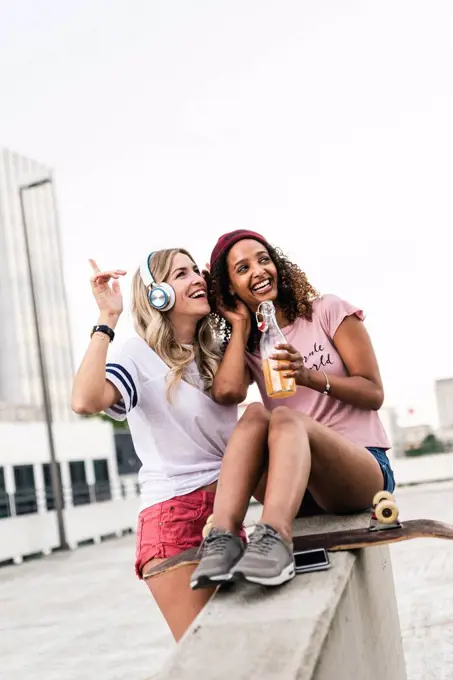 Best friends with skateboard, having fun together, listening music