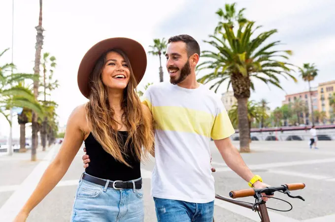 Spain, Barcelona, happy couple walking on seaside promenade