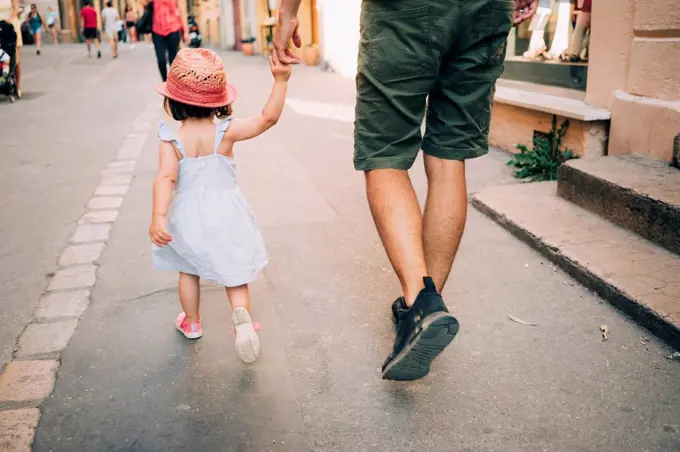 France, Aix-en-Provence, toddler girl and father walking hand in hand in the city