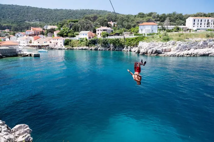 Croatia, Istria, Losinj, Rovenska, Young man bungee jumping