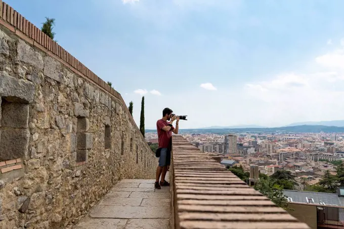 Spain, Girona, man at the castletaking picture of the city