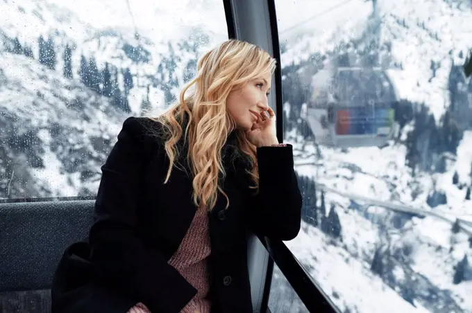 Switzerland, European Alps, Woman looking out at the mountain range from the cable car gondola