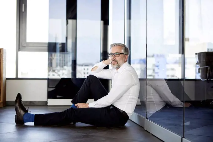 Businessman sitting on the floor in office