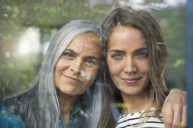 Mother and daughter looking out of window