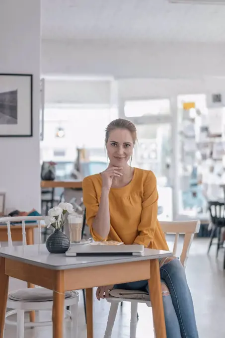 Young woman working in coworking space, taking a break