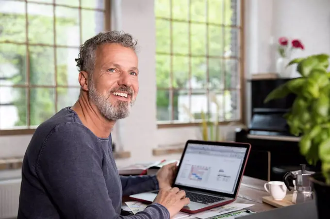 Mature man working in his home office at a loft apartment