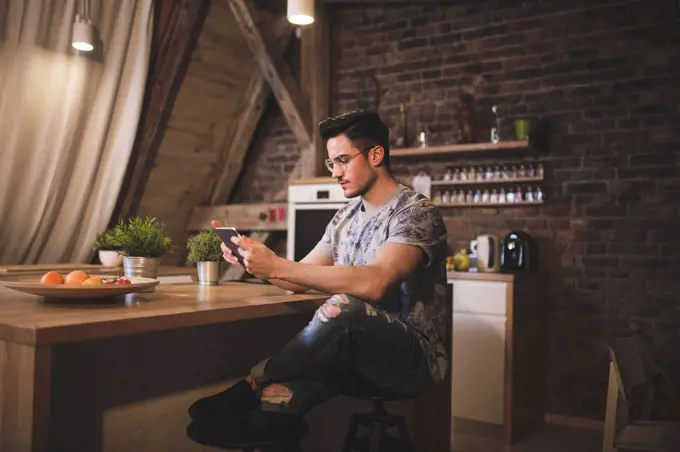 Young man using tablet in kitchen at home