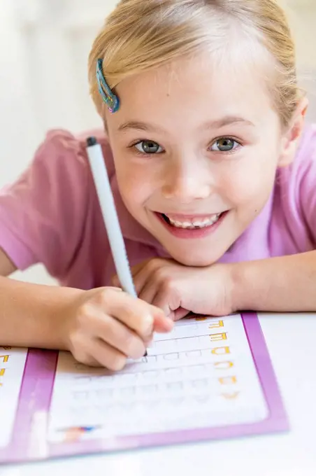 Portrait of smiling little girl writing alphabet