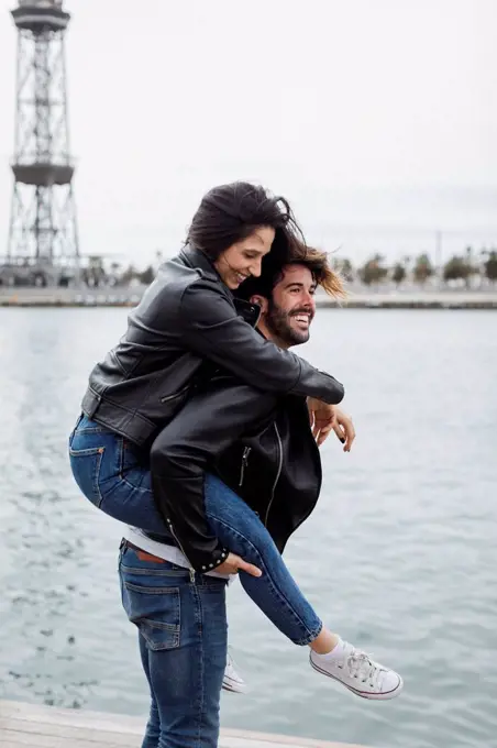 Spain, Barcelona, happy young couple having fun at the coast