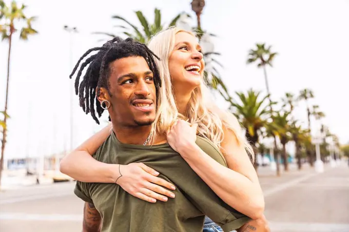 Spain, Barcelona, portrait of multicultural young couple on promenade