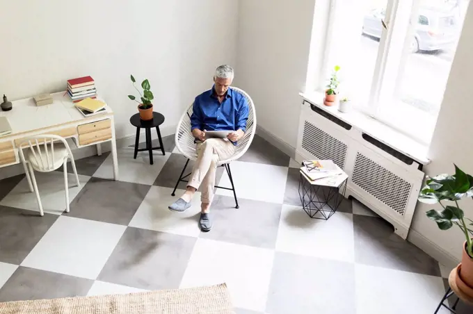 Mature man using tablet at home