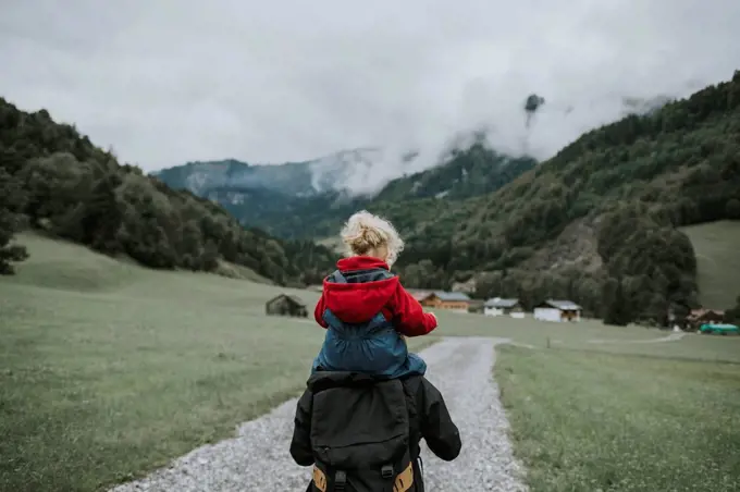 Austria, Vorarlberg, Mellau, mother carrying toddler on shoulders on a trip in the mountains