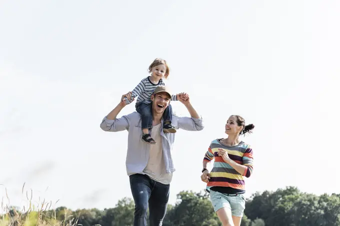 Happy family walking at the riverside on a beautiful summer day