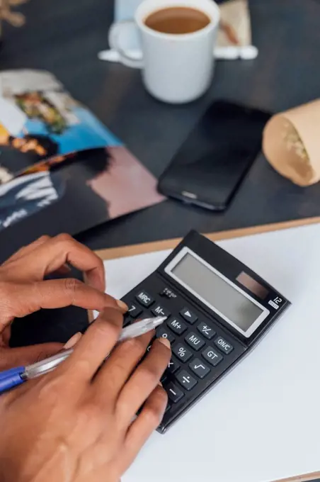 Hand of a woman using calculator