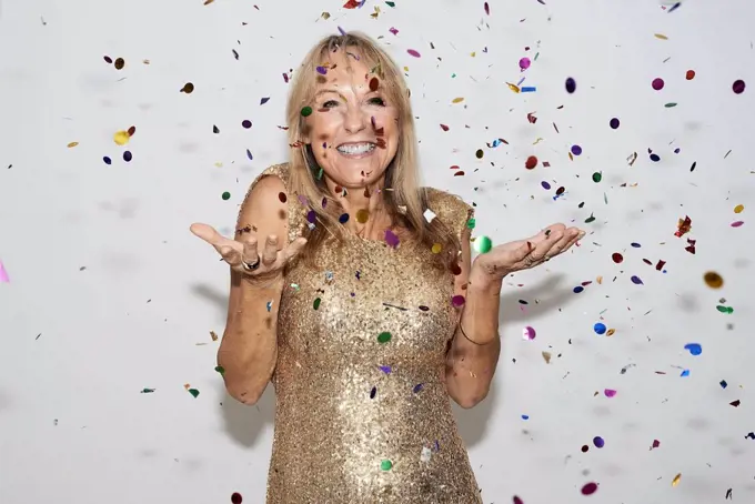 Senior woman wearing golden dress, celebtraing New Year's Eve