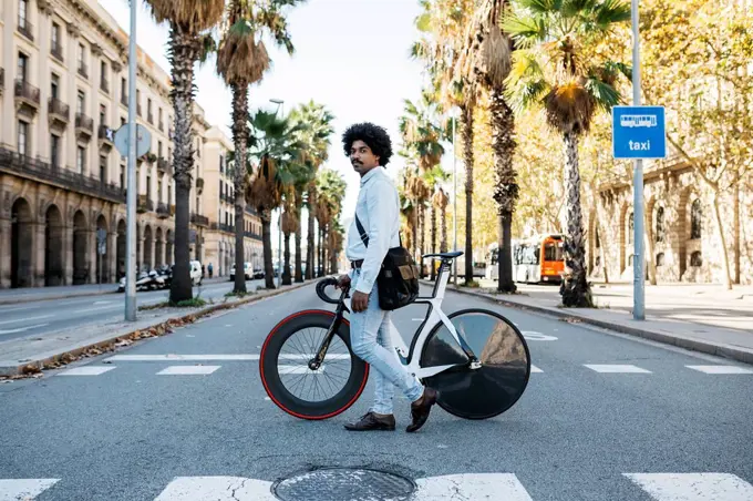 Man pushing his bicycle, crossing a road