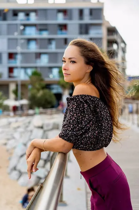 Portrait of beautiful young woman standing on promenade