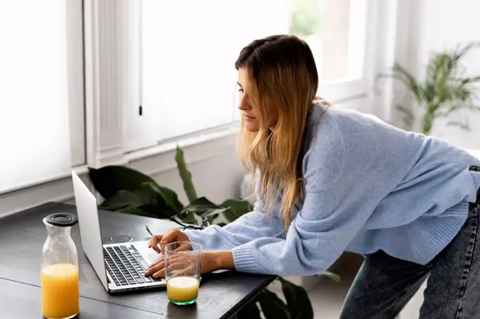 Young woman using laptop at home