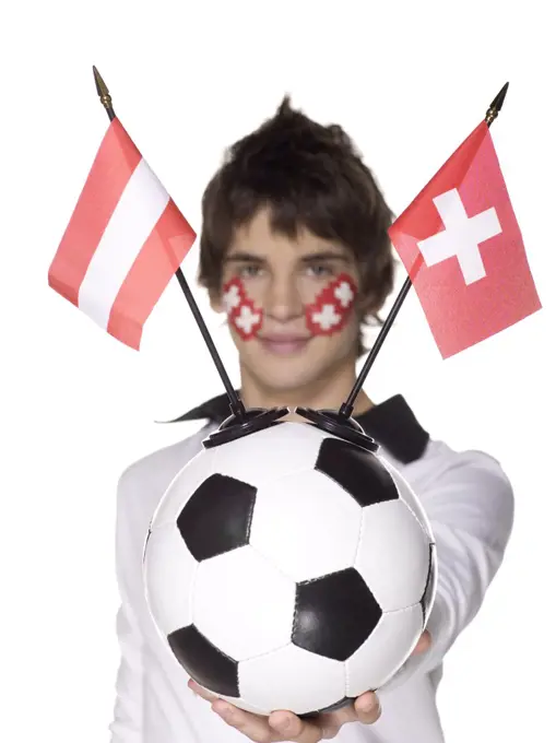 Man with Swiss flag painted on face holding football, Austrian and Swiss flag aside