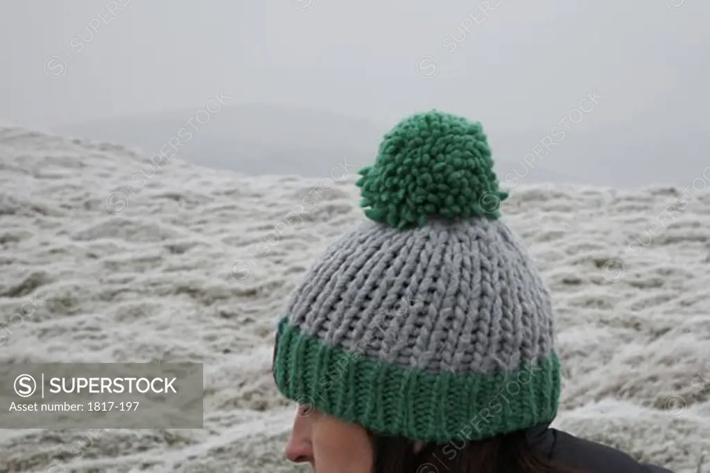 Young woman wearing woolly pom pom hat outdoors