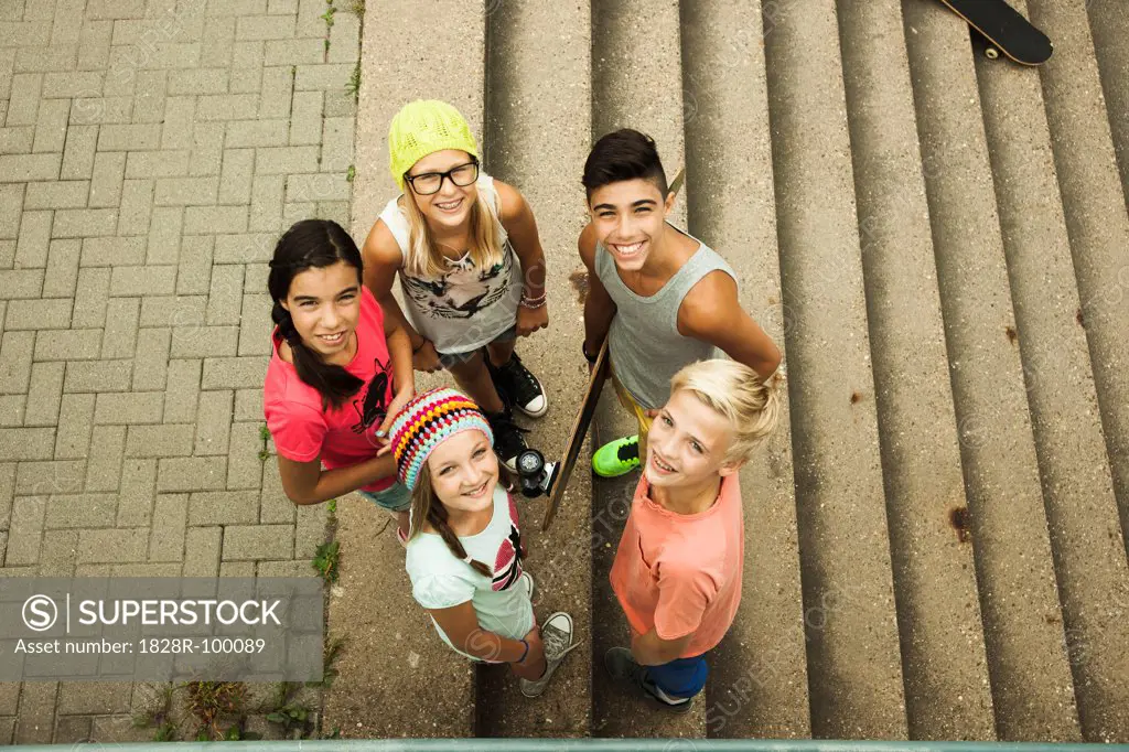 Group of children standing outdoors on cement staris, looking up at camera, Germany. 08/31/2013