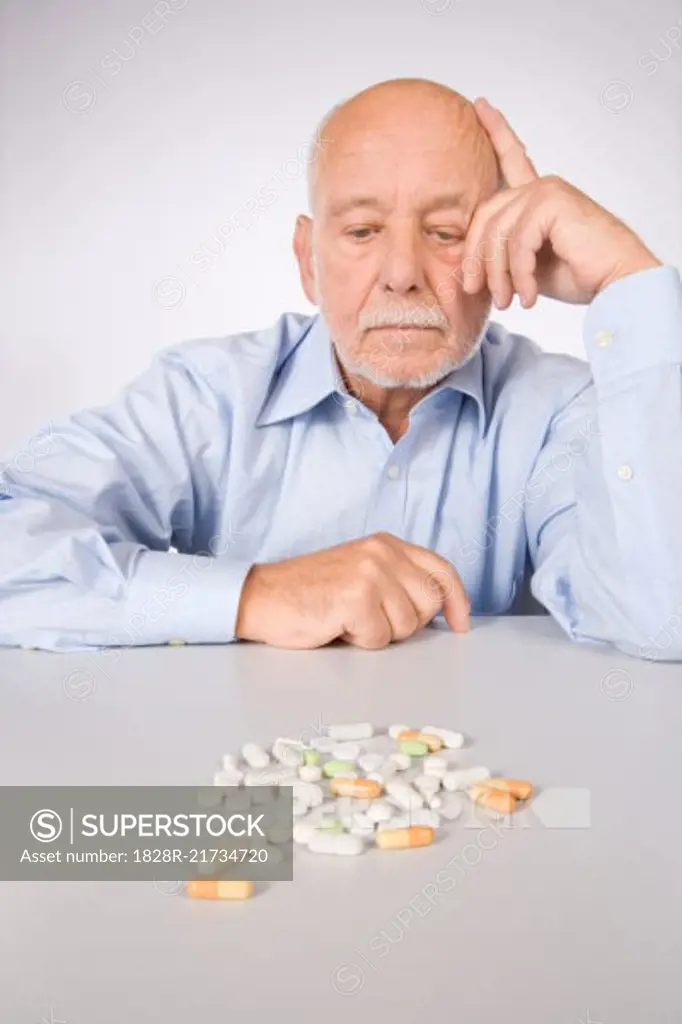 Man Looking at Pills   