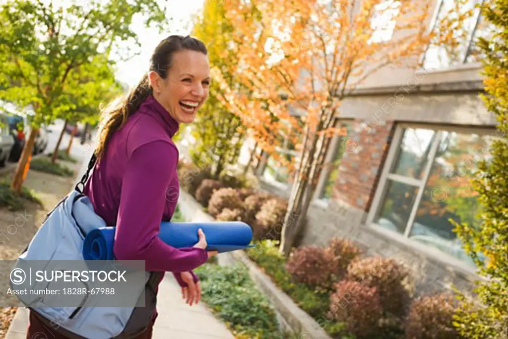 Woman Walking and Carrying Yoga Mat, Seattle, Washington, USA