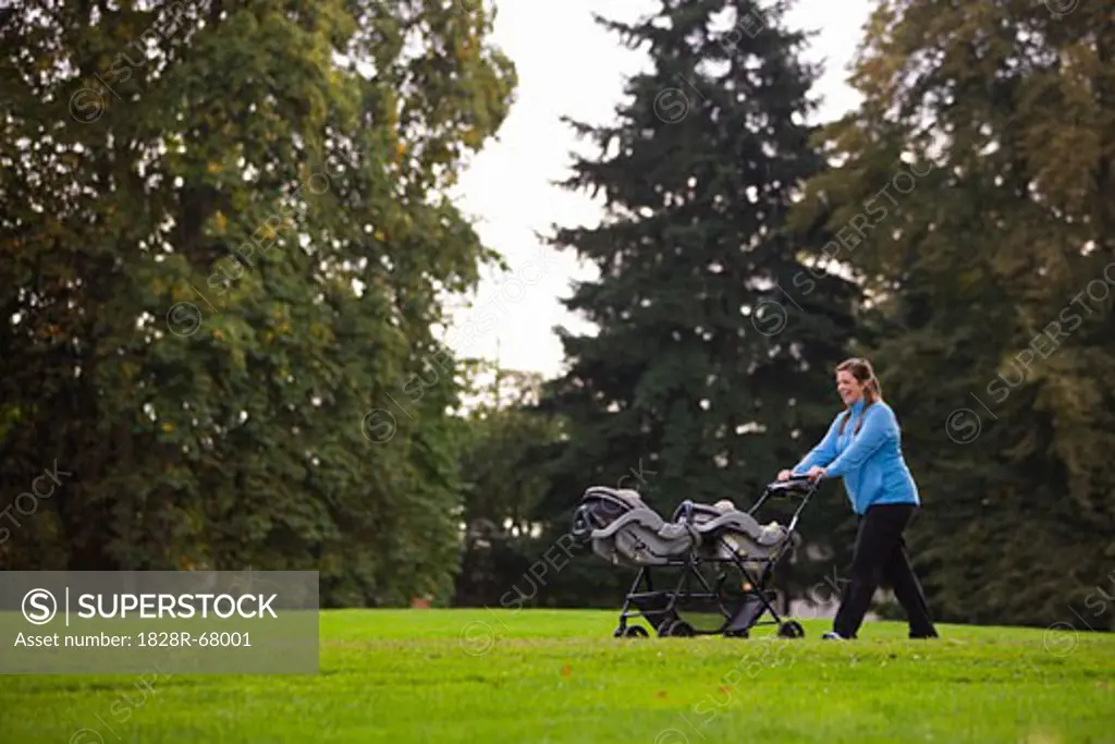 Woman Pushing Stroller in Park, Seattle, Washington, USA