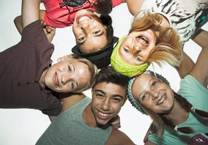 Group of children in circle, smiling and looking down at camera, Germany. 08/31/2013