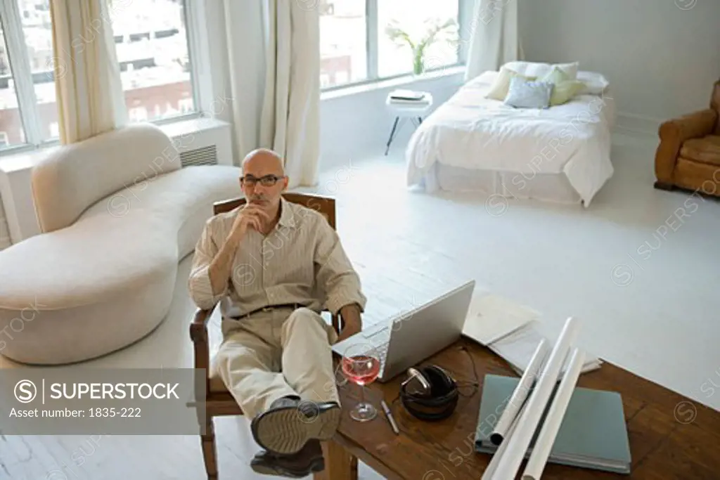 Mature man sitting on a chair with his feet up on a table