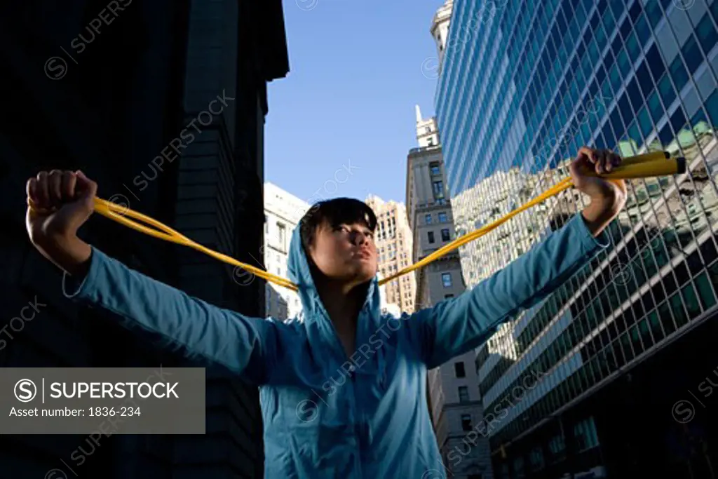 Low angle view of a young woman holding a jump rope